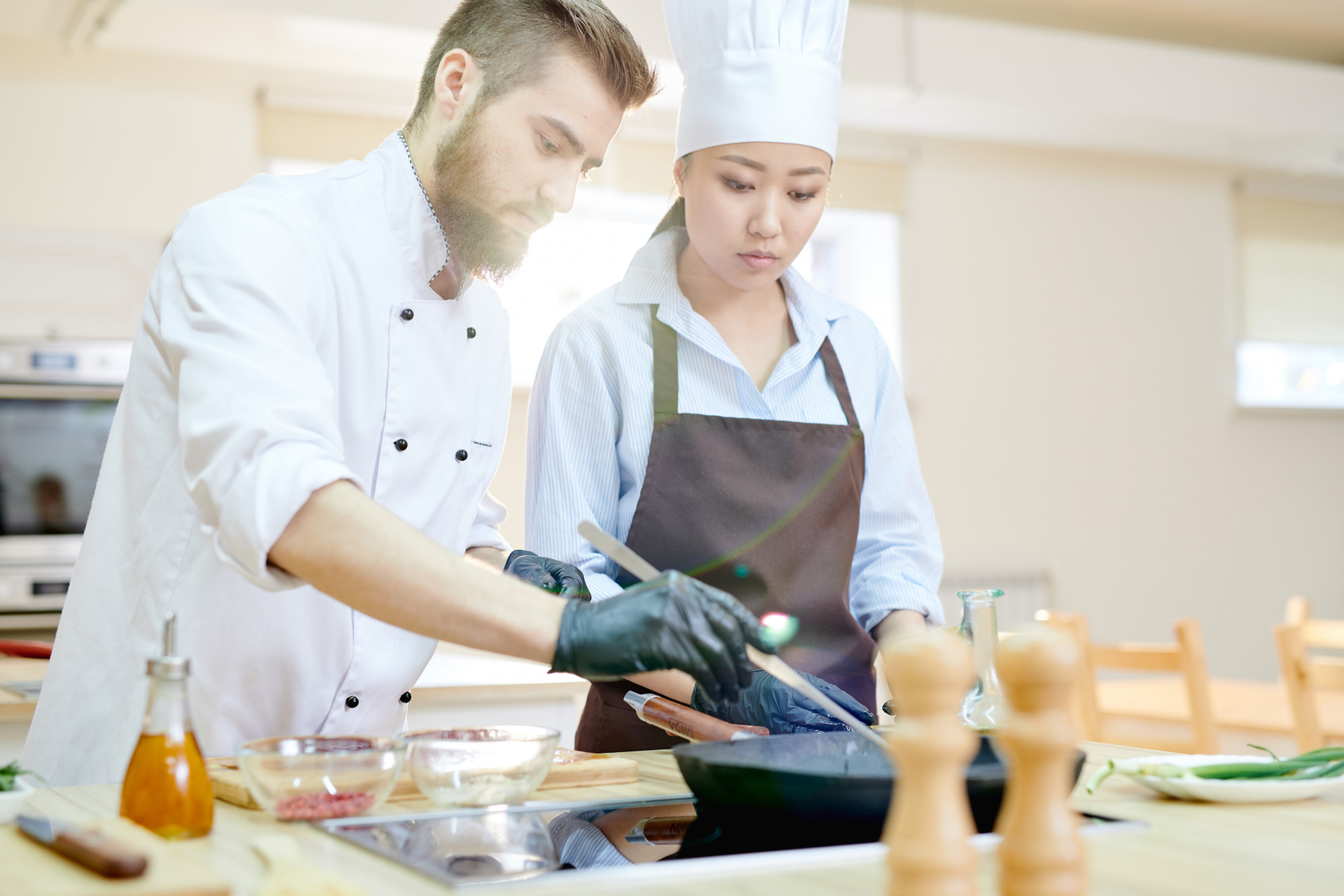 trainer demonstrating plating technique to kitchen staff